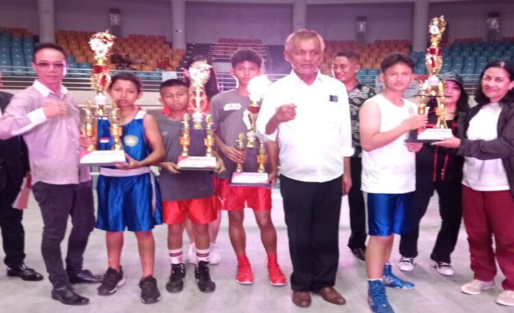 Promotor Ryan Thedlim (kiri), Yance Rahayaan (tengah), drg. Rina Siahaya (kanan), usai menyerahkan piala Universitas Prof. Dr. Moestopo Beragama kepada petiju amatir di GOR Laga Satria, Minggu, 13 Oktober 2024. (Foto: Istimewa)